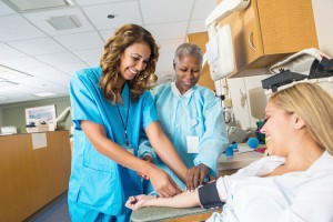 Doctor teaching nursing student to insert blood donation line